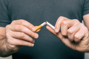 quitting smoking - male hand crushing cigarette