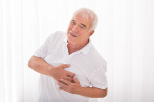 man with hand on chest suffering from heart attack