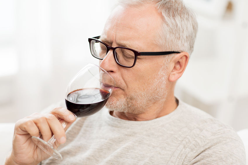 man drinking a glass of wine