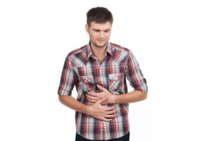 33194995 - young man with strong stomach pain isolated on white background. upset guy holding stomach and feeling pain
