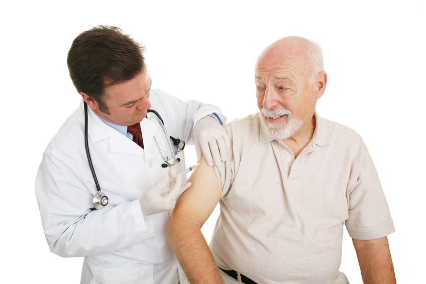 senior man getting a flu shot from his doctor. isolated on white.