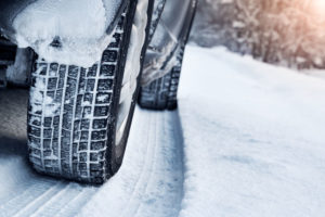 51353011 - closeup of car tires in winter on the road covered with snow