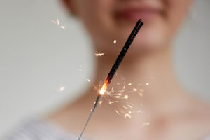84060988 - happy young girl holding a sparkler. the atmosphere of the festival.