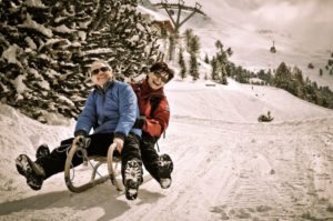 11549571 - active senior couple on sledge having fun in mountain snowy country