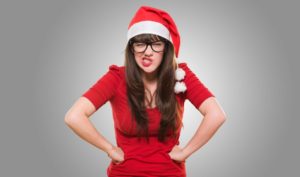 16291056 - angry christmas woman wearing glasses against a grey background