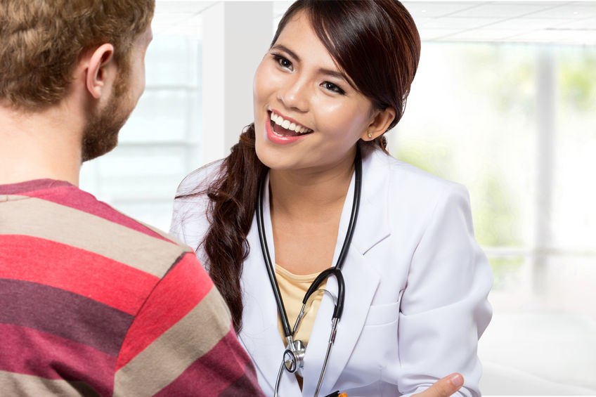 A portrait of a Smiling doctor giving a consultation to a patient in her medical office