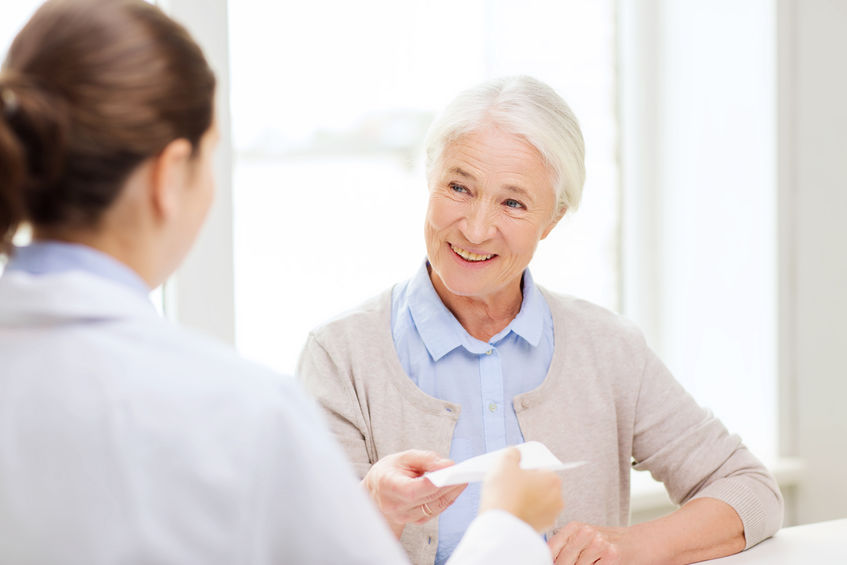 medicine, age, health care and people concept - doctor giving prescription to happy senior woman at hospital