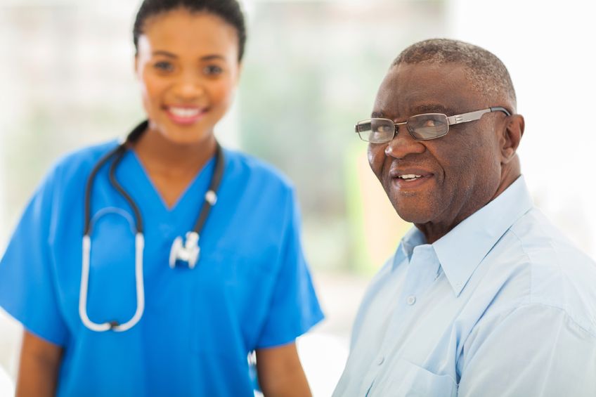 22198048 - smiling senior african american man in doctors office with nurse on background