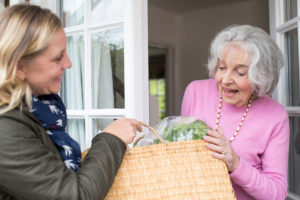 Female Neighbor Helping Senior Woman With Shopping