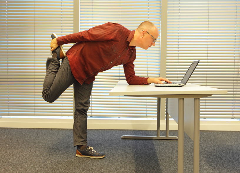 A guy standing and working at desk