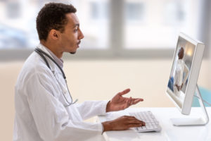 Doctor with a stethoscope on the computer laptop screen. Telemedicine or telehealth concept