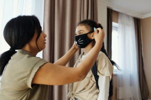 mother putting mask on her daughter