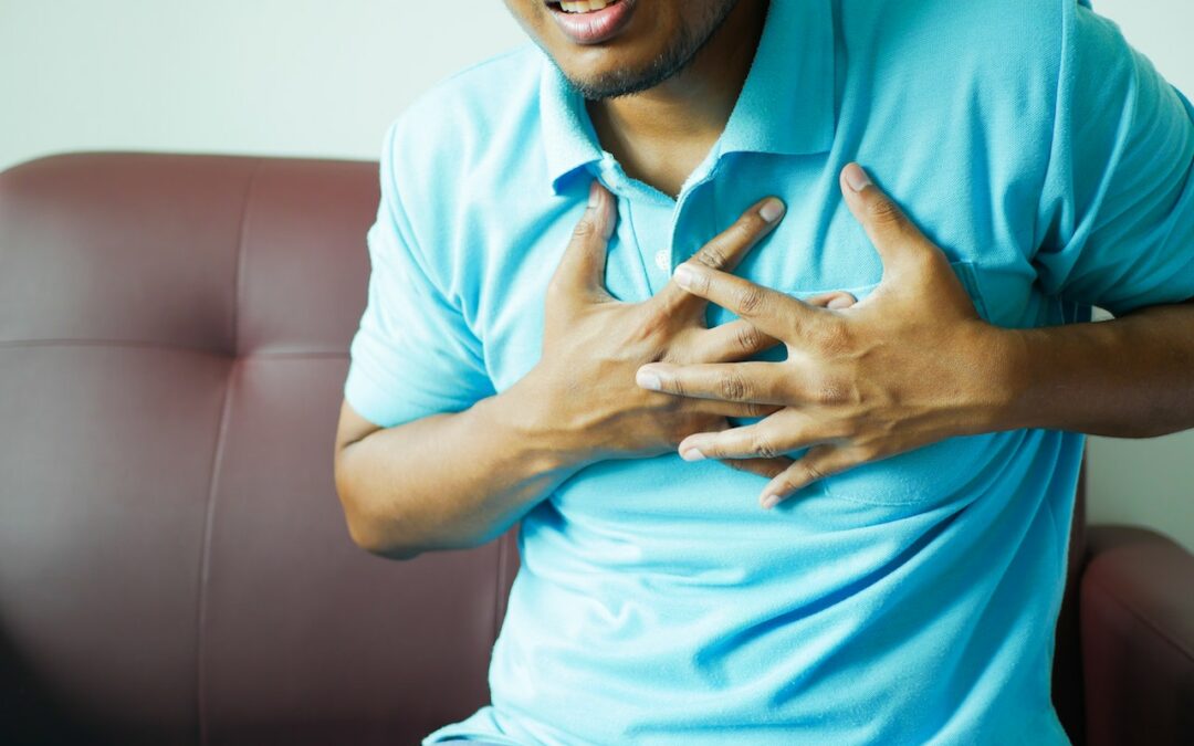 a man holding his chest as he experiences chest pain