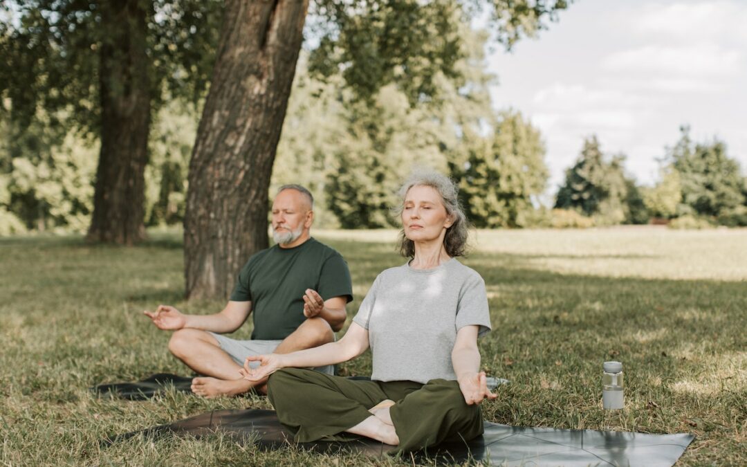 Couple sitting in park doing breathing exercises