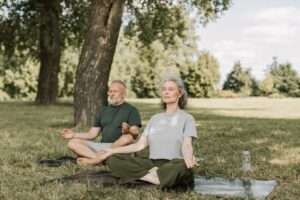 Couple sitting in park doing breathing exercises
