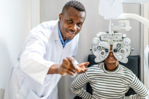 Optician doing optometry eye exam for teenager.