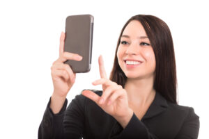 Closeup of cheerful businesswoman with smartphone. Isolated on white