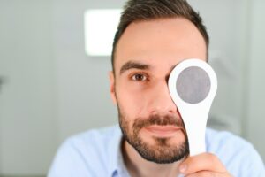 Portrait, vision and spoon with a man patient at the optometrist for an eye exam testing his depth perception.