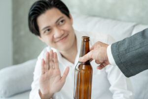 man smile and refuses say no and avoid to drink an alcohol , hand show reject and stopping, alcoholism treatment, alcohol addiction, quit booze, Stop Drinking Alcohol. Refuse bottle liquor, unhealthy
