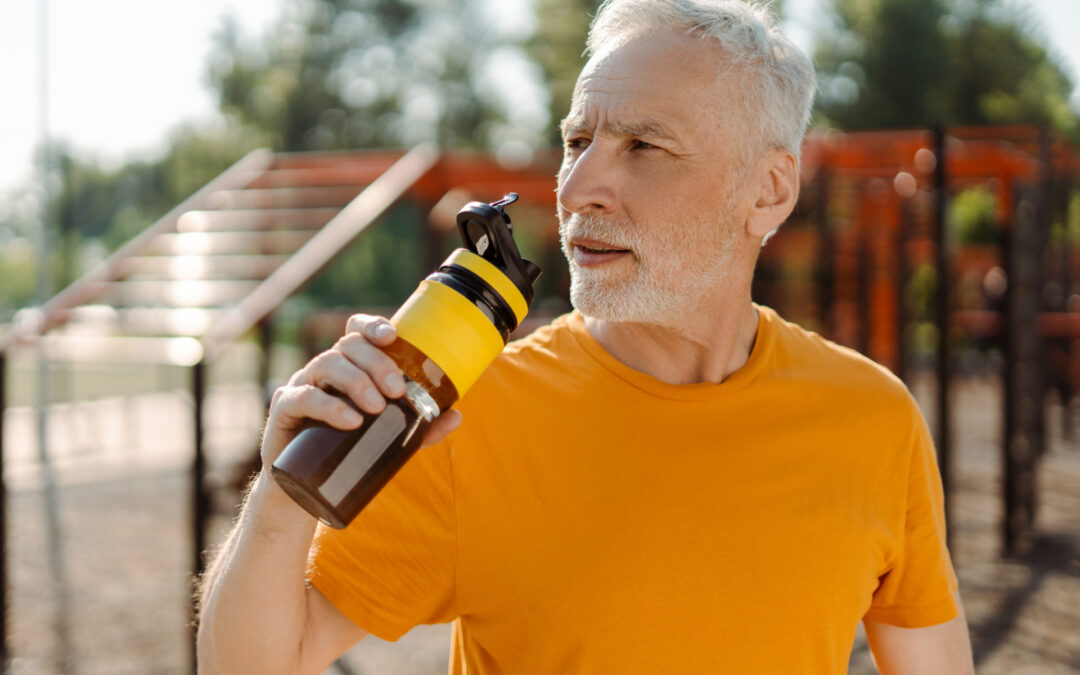 Elderly athlete hydrating after exercising on outdoor gym equipment, promoting senior fitness and healthy lifestyle